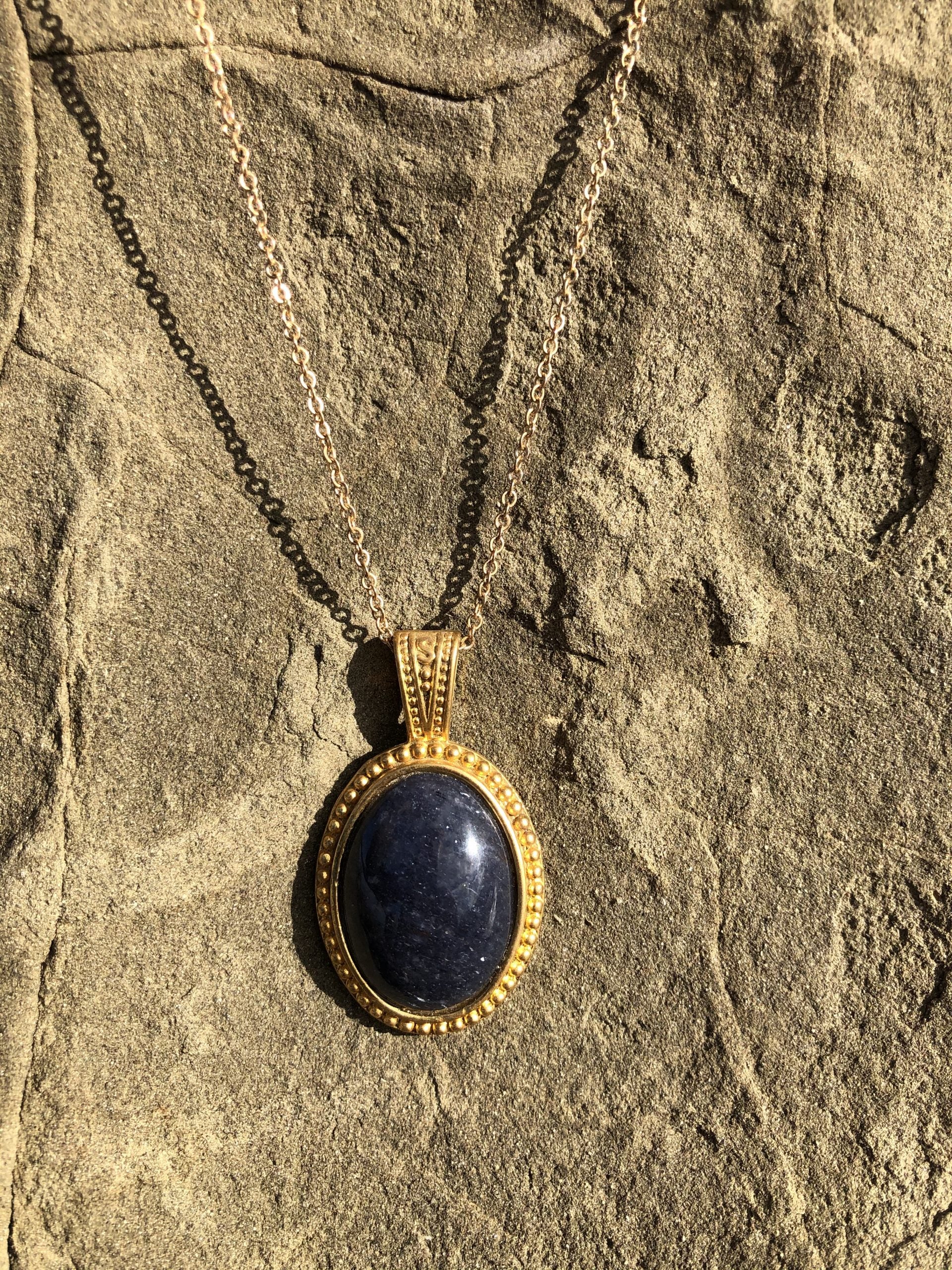 Necklace with natural blue aventurine, hand polished to a 25x18mm cabochon and set in a gold plated setting with 19 inch chain, on rock