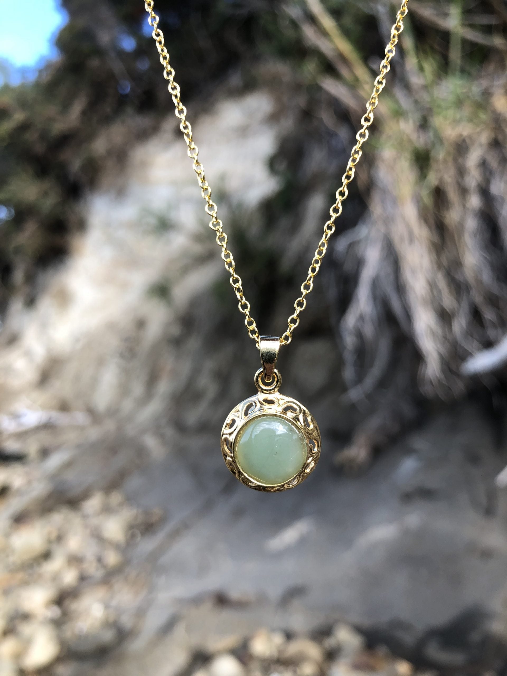 Necklace with natural green aventurine, hand polished to a 10mm round cabochon and set in a gold plated setting with 19 inch chain.