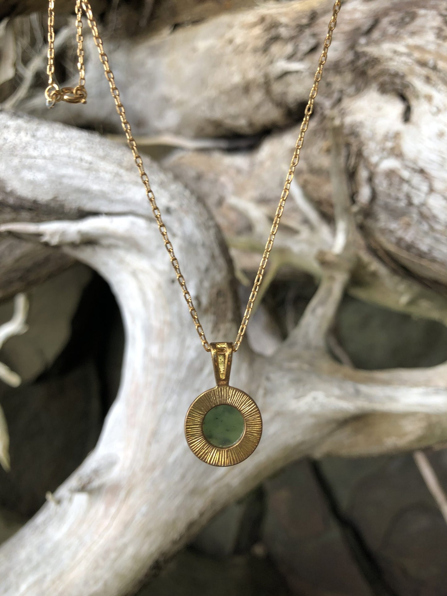 Necklace with natural Russian Nephrite Jade, bright green with black spots, hand polished to a 12mm round cabochon and set in a gold plated setting with 19 inch chain, back