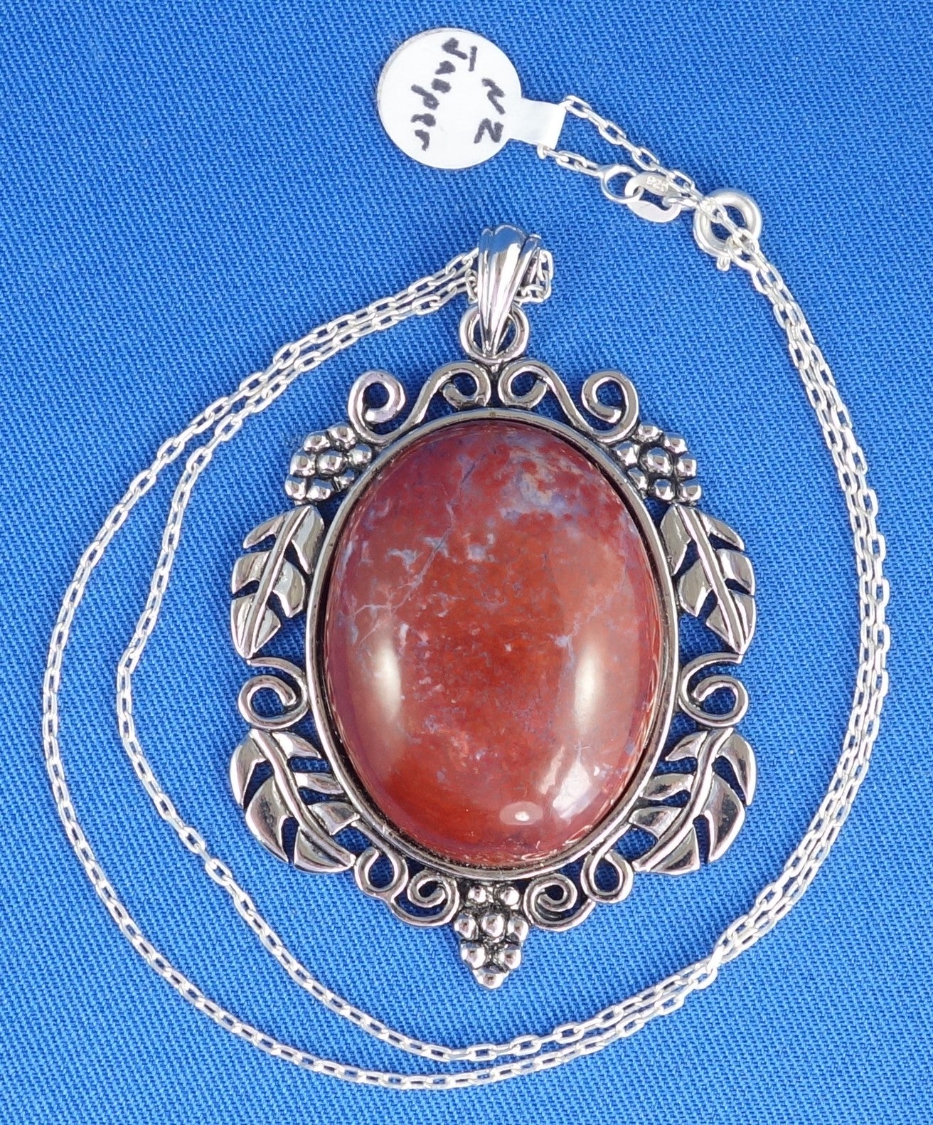 Necklace with a brilliant red jasper that I collected from the West Branch of the Tairua River in Coromandel Peninsula with speckles of blue chalcedony and all the colours of the chakrahs. This stone is hand polished into a 40x30mm cabochon and set in a silver plated setting with 19 inch chain. As you study the subtle speckles and swirls you can see the main grounding red, orange, yellow, pink, blue and white.