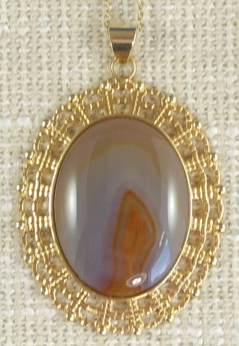 Necklace with Indian agate carefully cut with a candle flame figure dancing in the center of the hand polished 40x30mm cabochon, set in gold plated setting with 19 inch chain.