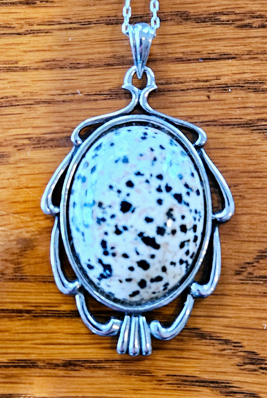 Necklace with Dalmation Jasper from Mexico with black and tan spots on white background, hand polished into a 40x30mm cabochon and set in a silver plated setting with 19 inch chain.