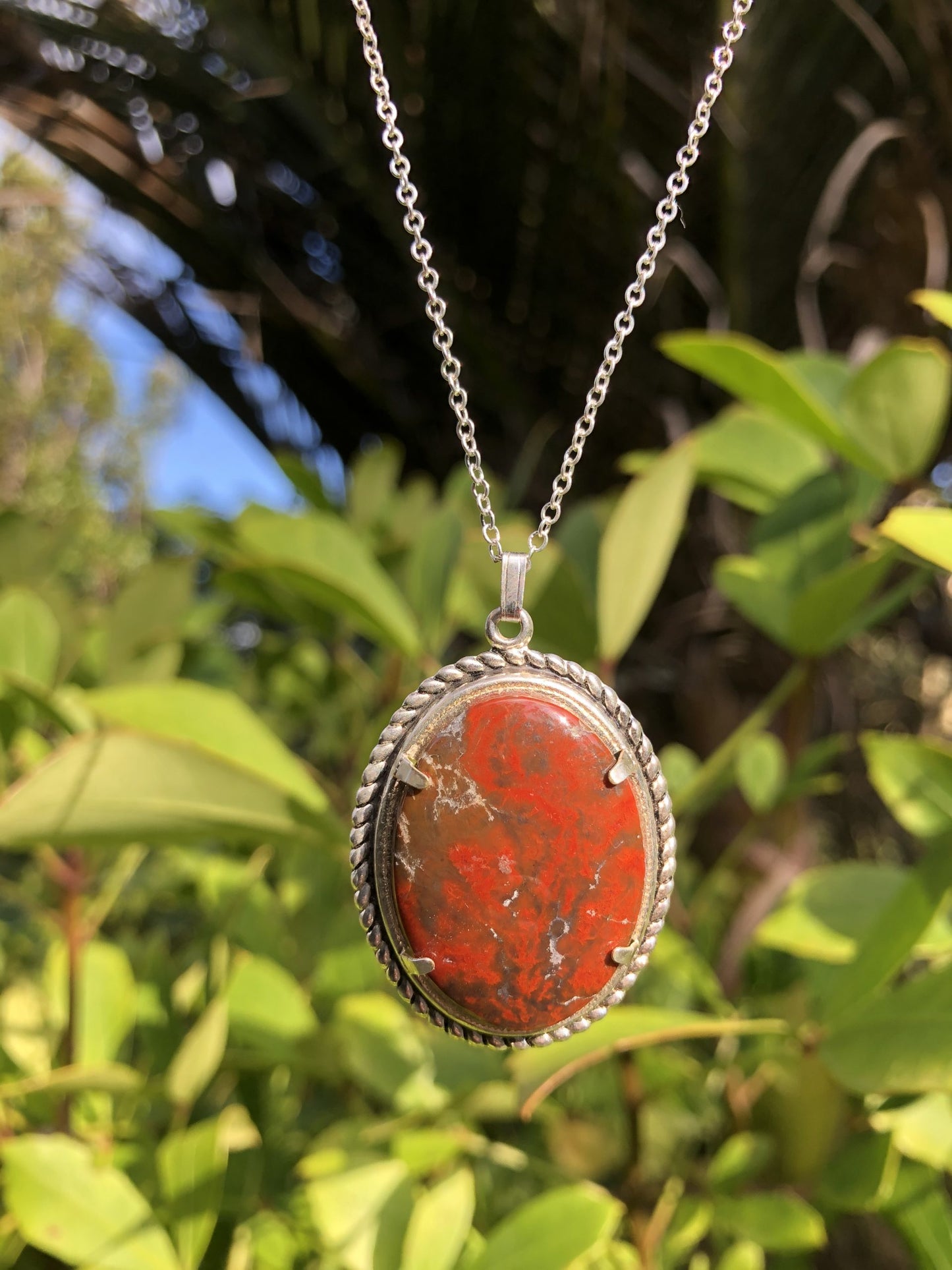 Necklace with Mary-Ellen Jasper from USA (believed to be a petrified sea algae colony) with bright red swirls on a black and white background, hand polished to a 30x22mm cabochon and set in a silver plated setting with 19 inch chain, in garden