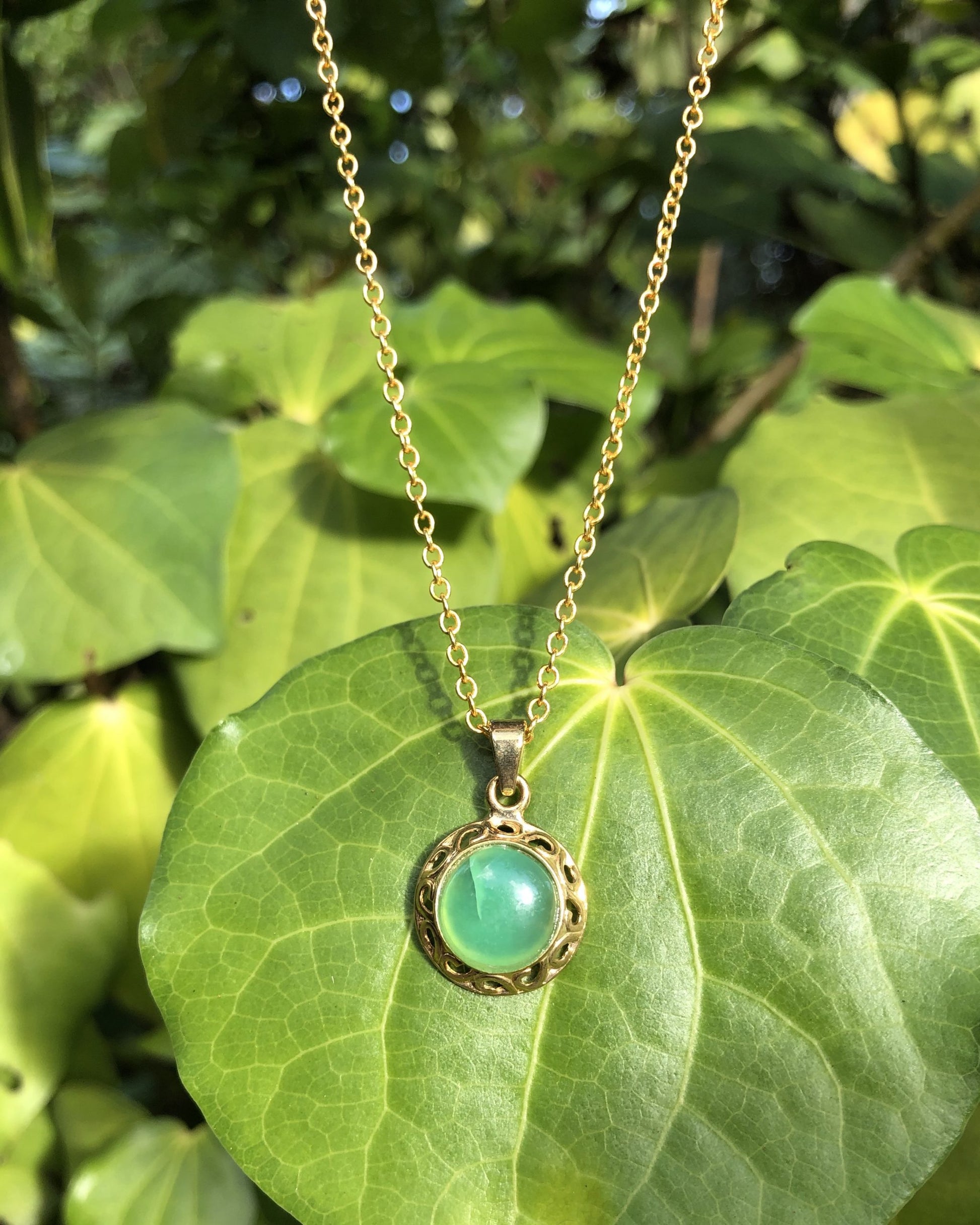Necklace of brilliant green Australian Chrysoprase, hand polished to a 10mm round cabochon and set in a gold plated setting with 19 inch chain.