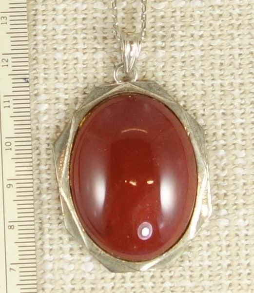Necklace of bright red jasper from Coromandel New Zealand, hand polished into a 40x30mm cabochon and set in gold plated setting with 19 inch chain.