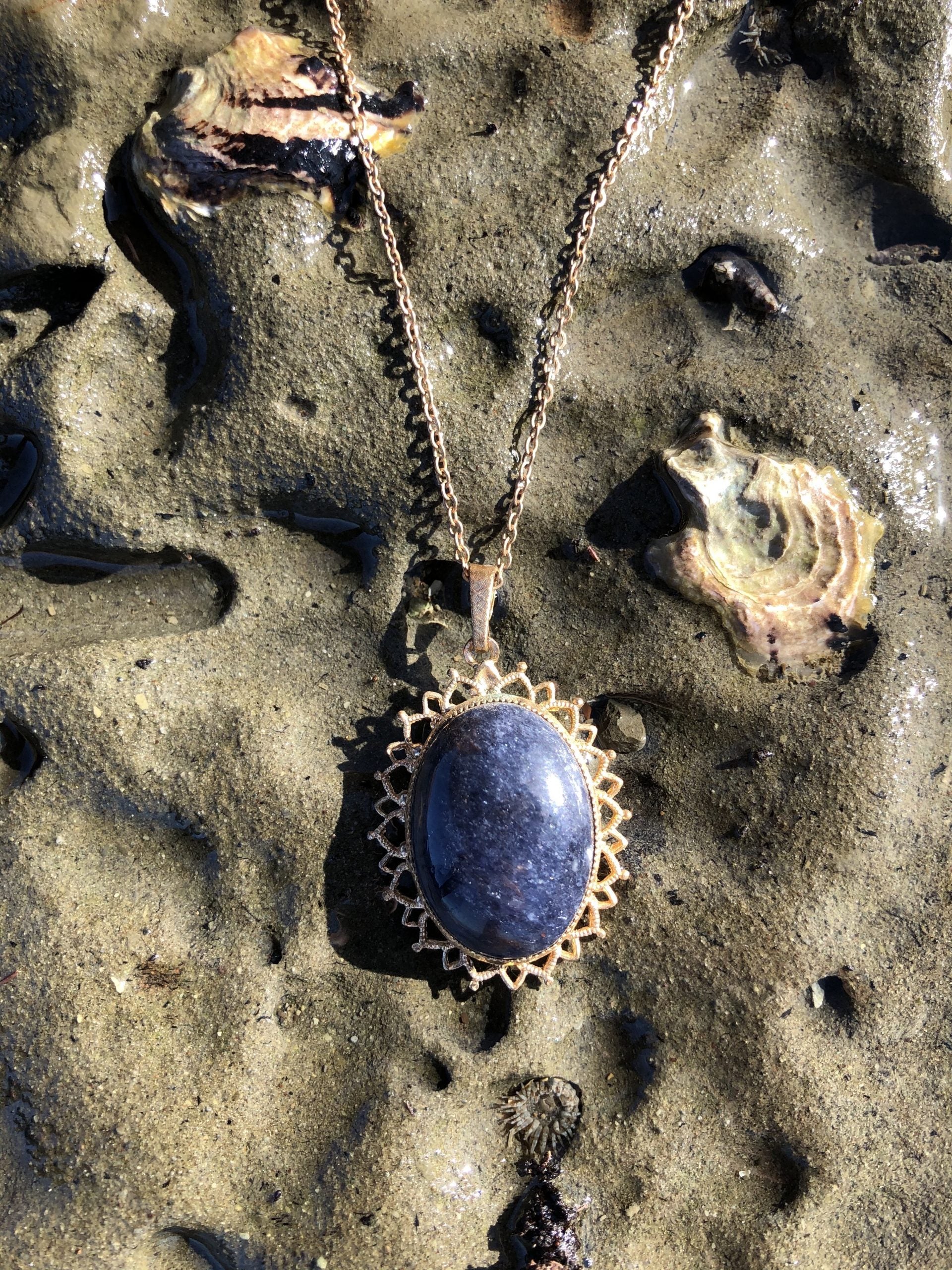 Necklace with natural blue aventurine, hand polished to a 25x18mm cabochon and set in a gold plated setting with 19 inch chain, on sand