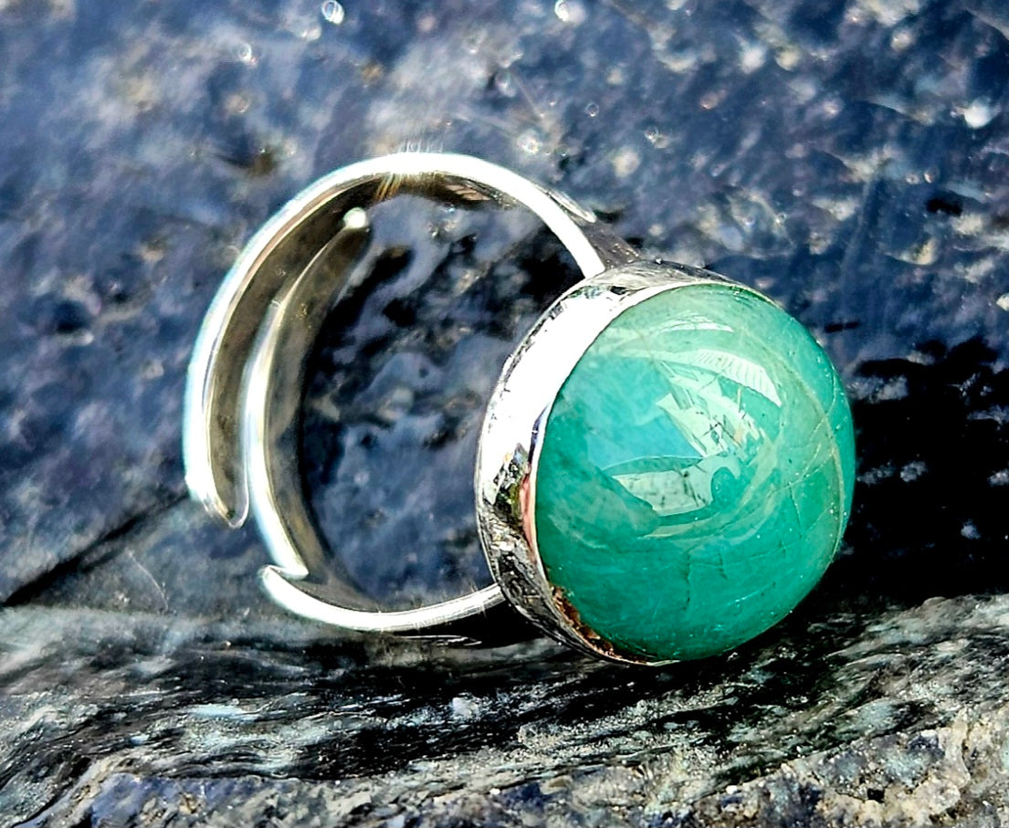 A rich green Aventurine, hand cut and polished to an 18x13mm cabochon and set in a sterling silver, adjustable ring, side.
