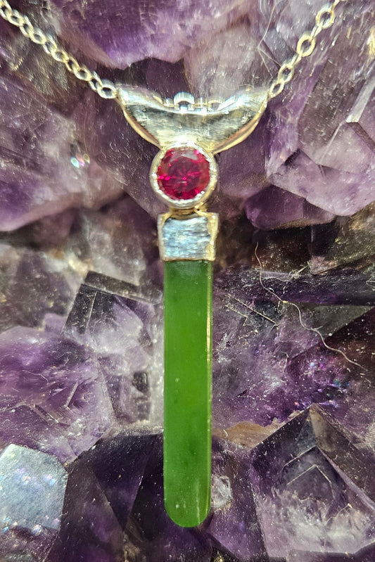 Necklace with bright, apple green Kahurangi Pounamu drop, 25mm long with a bright red lab-grown real 5mm ruby, front.
