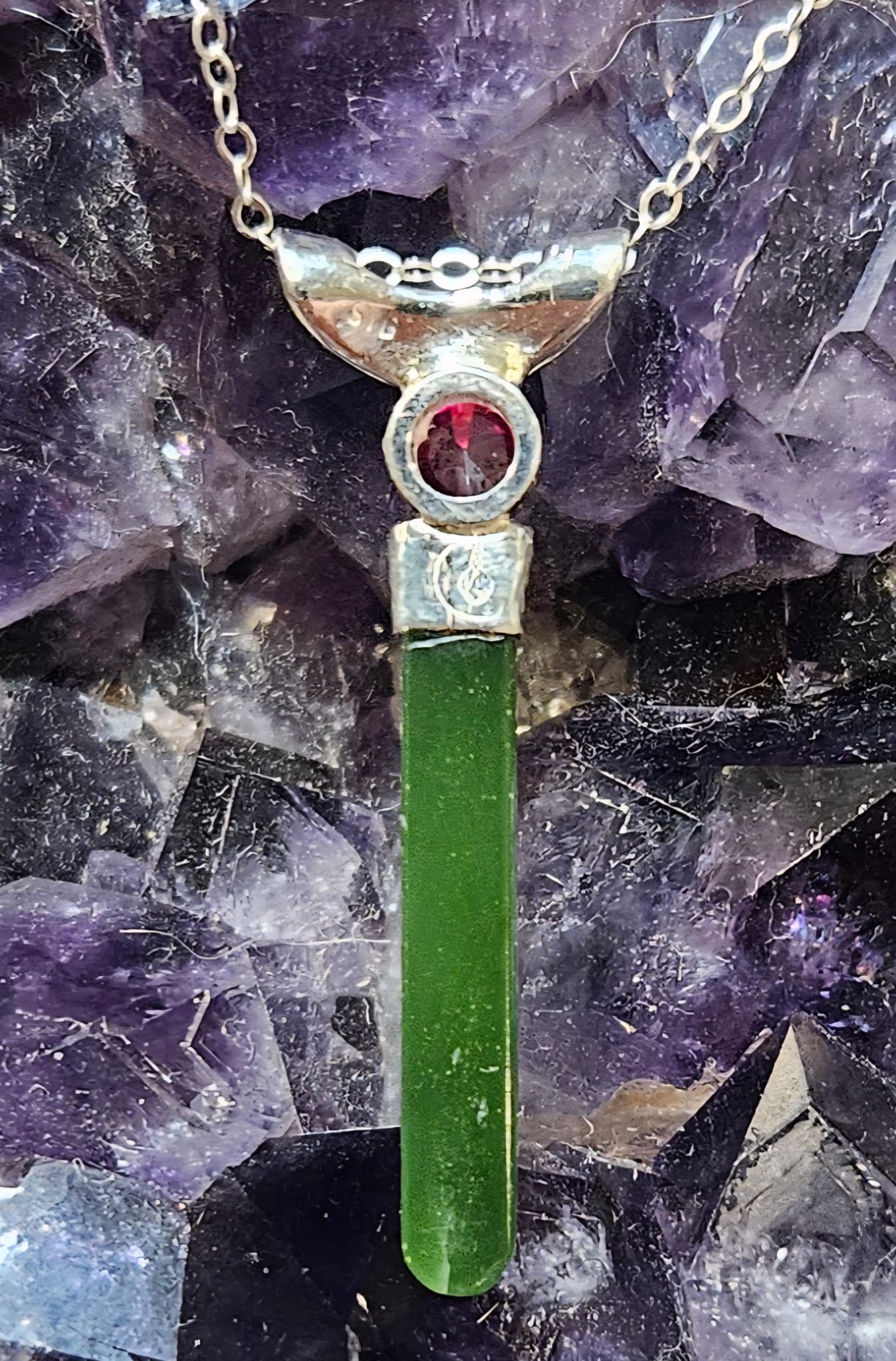 Necklace with bright, apple green Kahurangi Pounamu drop, 25mm long with a bright red lab-grown real 5mm ruby, back.